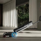 A woman in a white dress effortlessly using the maneuverable Dreame H15 Pro wet and dry vacuum to clean up a spilled egg and broken shell from a concrete-style floor in a bright, modern home.