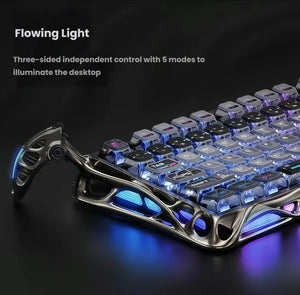 Close-up side view of the GravaStar Mercury K1 Lite gaming keyboard highlighting its three-sided flowing LED lighting. The vibrant blue and purple glow from the front, sides, and under-chassis illuminates the desk, offering five customizable lighting modes for immersive gaming setups.