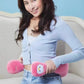 A woman holding the pink OSIM uSnooz massage wrap with Donald Duck faces, using it as a waist support cushion. The plush design offers comfort and flexibility for multiple body positions.