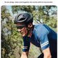 Man cycling outdoors wearing Shokz OpenRun Pro 2 bone conduction headphones with no earplugs, ensuring safety and hygiene during rides