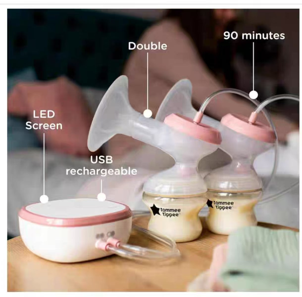 Tommee Tippee double breast pump in use, showing full setup with two bottles filled with milk. Features USB-rechargeable motor unit, LED screen, and 90-minute runtime indicator.